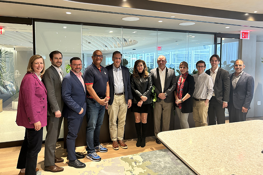 Political Science Advisory Board members gather in front of a glass window.